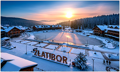 Северна капија Златибора - Северна капија Златибора представља географски и културолошки праг планине, зону где се под утицајем специфичне геоморфолошке структуре и преплитања различитих ваздушних струја формира јединствени планински амбијент карактеристичан по пространим пропланцима и дубоким речним усецима. Овај део планине, који обухвата атаре села Мачкат, Крива Река и Трипкова, историјски је познат као тачка додира трговачких путева који су повезивали унутрашњост Србије са јадранском обалом, што је директно утицало на развој локалне економије засноване на преради производа од меса и камена. Специфичност северне капије огледа се у њеној климатској динамици, где се хладнији планински ваздух са врхова сусреће са нешто топлијим струјама из Пожешке котлине, стварајући идеалне услове за природно сушење и ферментацију прехрамбених производа, што је село Мачкат позиционирало као епицентар златиборске гастрономије. Архитектонски идентитет северних златиборских села карактеришу старе занатске радионице и породична имања која су задржала аутентичне елементе градње, са високим каменим подзидама и кровним конструкцијама које су пројектоване да издрже притисак тешких зимских снегова и оштрих ветрова. У селу Трипкова, традиција обликовања стакла и керамике представља мост између традиционалних вештина и модерне уметности, док Крива Река својим именом и хидрографском мрежом указује на снагу водених токова који су током векова моделовали пејзаж овог дела Златибора. Биодиверзитет северне капије карактерише семена заступљеност букових и храстових шума које у нижим деловима постепено прелазе у четинарске заједнице белог бора, стварајући богату еколошку нишу за развој лековитог биља и гљива које мештани сакупљају деценијама. Културно наслеђе овог подручја живо је кроз народна окупљања и манифестације које славе занатско порекло и пољопривредну снагу златиборског сељака, чија је издржљивост и мудрост уткана у сваки камени крајпуташ и сваку дрвену капију која дочекује путнике из правца Ужица. Стратешки значај овог предела огледа се и у очуваним археолошким остацима који потврђују насељеност још из периода праисторије, док савремени развој северне капије тежи балансу између очувања изворног златиборског духа и потреба модерног туризма. Свака слика северне капије Златибора носи у себи запис о снази земље која хранећи своје становнике, чува сећање на генерације неимара, трговаца и домаћина који су својом вештином обележили ову планинску добродошлицу.