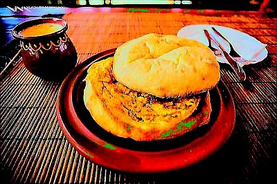 Село Мачкат, позиционирано на стратешком прелазу између златиборске висоравни и нижих брдских предела, представља јединствену микроклиматску оазу која је вековима дефинисала развој најпознатијег српског гастрономског бренда – златиборске пршуте. Смештено на специфичној надморској висини где се укрштају планински ваздух са Тарне и Муртанице са топлијим струјама које долазе из долине Ђетиње, Мачкат користи овај природни вентилациони систем за спору и природну ферментацију меса у традиционалним сушарама. Ове грађевине, често старе и преко стотину година, зидане су од камена и дрвета тако да омогућавају сталан проток ваздуха, док се за димљење користи искључиво суво буково дрво, што месу даје карактеристичну боју, текстуру и арому која је препозната на међународном нивоу. Традиција прераде меса у Мачкату није само економска грана, већ породично наслеђе које се преноси кроз генерације, где свака фамилија чува своје специфичне рецептуре за сољење и време излагања диму, чинећи ово село живим музејом укуса. Сајам сувомеснатих производа, популарна Пршутијада, сваке године претвара Мачкат у центар окупљања гурмана и произвођача, славећи вештину која почива на поштењу према природи и поштовању старих метода производње без употребе вештачких адитива. Поред пршуте, Мачкат је чувен и по својој јагњетини, где печењаре дуж главног пута представљају незаобилазне тачке за сваког путника намерника, нудећи укус који је резултат испаше стоке на лековитим златиборским пашњацима. Ова гастрономска култура дубоко је уткана у свакодневни живот мештана, који су својим радом и упорношћу успели да одрже село виталним, богатим и привлачним за младе генерације које остају на кућном прагу, настављајући традицију својих предака.  Културна и архитектонска мапа Мачката открива слојевиту историју овог краја, почевши од велелепне цркве Светог пророка Илије, која својом витином и положајем доминира сеоским пејзажом, служећи као духовни стожер становништва од деветнаестог века. Порта цркве је традиционално место саборивања, где се и данас негују народни обичаји, изворна песма и игра, чувајући етнолошки идентитет северног Златибора. Урбана структура села карактерише се комбинацијом модерних економских објеката и старих златиборских кућа са високим подзидама и дрвеним тремовима, што сведочи о постепеној еволуцији Мачката од сточарског насеља до богатог прерађивачког центра. Основна школа у Мачкату, једна од најстаријих у овом делу Србије, била је кроз историју светионик писмености, а данас је симбол демографске стабилности села које се не празни, већ развија и модернизује. Околина села обилује природним лепотама, са благим бреговима који су током пролећа и лета прекривени цветним теписима мајчине душице и кантариона, док бројни извори питке воде потврђују еколошку чистоћу овог терена. Мачкат је познат и по каменоресцима и зидарима који су своју вештину каљења камена пренели на изградњу чесама и споменика крајпуташа, који стоје као неми чувари сећања на ратнике и путнике из прошлих времена. Друштвени живот Мачката пулсира кроз локалне кафане, које су одувек биле места договора, трговине и приповедања, где се уз чашицу домаће ракије револуционарне идеје преплићу са свакодневним пољопривредним темама. Овај склад између индустрије укуса, духовности и природног окружења чини Мачкат једним од најфункционалнијих и најлепших златиборских села, где се успех мери поштовањем традиције и спремношћу да се угости сваки путник као најрођенији, пружајући му најбоље што планина може да подари. Мачкат није само успутна станица на путу ка мору, већ дестинација која својом снагом и карактером дефинише савремени идентитет Златибора, спајајући сурову лепоту крша са господским духом домаћина.