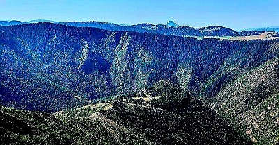 Село Стубло представља један од најизолованијих и духовно најзначајнијих предела јужног Златибора, позиционирано на стрмим и разуђеним падинама које се са висоравни Муртенице сурово обрушавају ка меандрима реке Увац, дефинишући амбијент исконске дивљине и светости. Овај предео карактерише специфична геоморфолошка градација где се кречњачки гребени преплићу са серпентинитним одсецима, стварајући кањонску клисуру нестварне дубине која је вековима служила као савршено скровиште за православну духовност и народни збег. Стубло је у националној историји и култури препознато као чувар два обновљена манастирска комплекса – Увца и Дубраве, који својом белином и касном средњовековном архитектуром стоје у нестварном контрасту са тамним бојама околних четинарских шума и сивилом стена. Хидрографски идентитет села нераскидиво је везан за моћну реку Увац, чија тиркизна боја воде и карактеристични меандри чине визуелно језгро овог предела, док бројни скривени извори и потоци који теку кроз село напајају ову сурову земљу и омогућавају опстанак специфичног биодиверзитета. Архитектура Стубла је сведена и функционална, са кућама грађеним од тесаног камена и брвнима које су постављене на тачке са којих пуца поглед на хоризонте Старог Влаха, пружајући мештанима осећај слободе и бесконачности. Економија села је и данас окренута природи, са фокусом на традиционално сточарство и прикупљање шумских плодова, док манастирска газдинства оживљавају старе занате и производњу еколошких производа по вековним рецептурама. Еколошка вредност Стубла је непроцењива, јер се већи део атара налази у оквиру специјалног резервата природе где су станишта белоглавог супа, чији лет изнад кањона представља симбол нетакнуте природе и очуваности екосистема. Мистичност овог краја појачана је тишином која влада у манастирским портама, испресецана само хуком реке из дубине и зовом птица грабљивица, стварајући амбијент идеалан за контемплацију и повратак духовној суштини. Стубло је место где се осећа снага вере и снага земље, где свака стаза прекривена иглама борова и сваки камени крст поред пута причају причу о издржљивости златиборског човека који је овде пронашао мир у најсуровијем загрљају планине. Слика Стубла није само пејзаж, већ је то дубока метафора о трајању и васкрсењу, где се из рушевина старих храмова издиже нови живот, сведочећи о неуништивости духовног наслеђа које је овде, на ивици кањона, нашло своју вечну кућу. Посета овом селу нуди искуство које мења перцепцију времена и простора, подсећајући нас на лепоту која произилази из једноставности, молитве и потпуног склада са неукротивом природом која овде суверено господари.