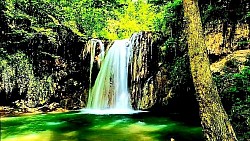 Ушушкано планинско село које полако тоне у сутон  Златни снопови сунца који се преламају кроз крошње јела